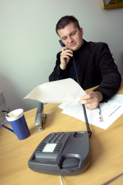 zdjęcie: mężczyzna przy biurku czyta dokumenty