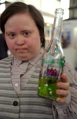 kobieta z zespołem downa trzyma zrobioną przez siebie butelkę