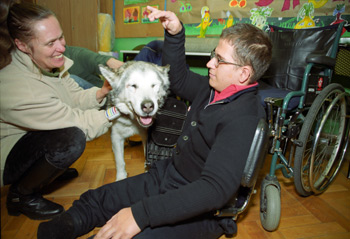 chłopiec z niepełnosprawnością głaszcze psa