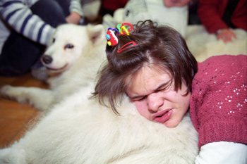 Na zdjęciu: Dogoterapia - dziewczyna przytula się do psa