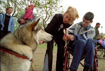 asystentka pokazuje psa chłopcu na wózku