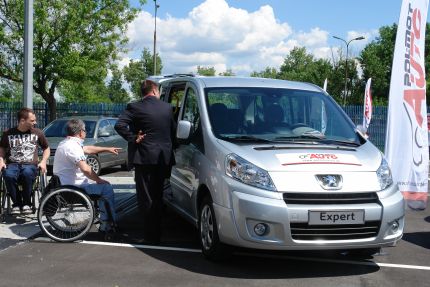 Osoby na wózkach oglądają samochód Peugeot Expert.